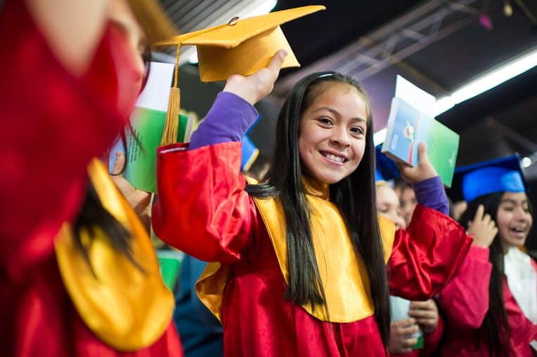 Cinthya rejoices at her graduation with her certificate and New Testament.