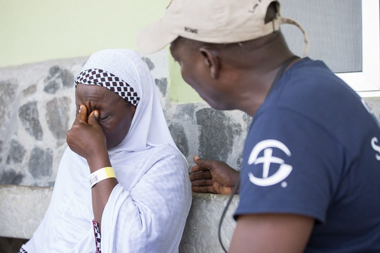 Thomas Benson comforts Fatima* as she relives the horror of the Ebola crisis.