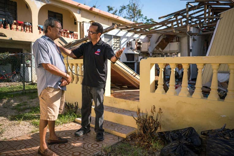 Pastor Miguel Ortiz encourages a homeowner who received a generator and tarp from Samaritan’s Purse.