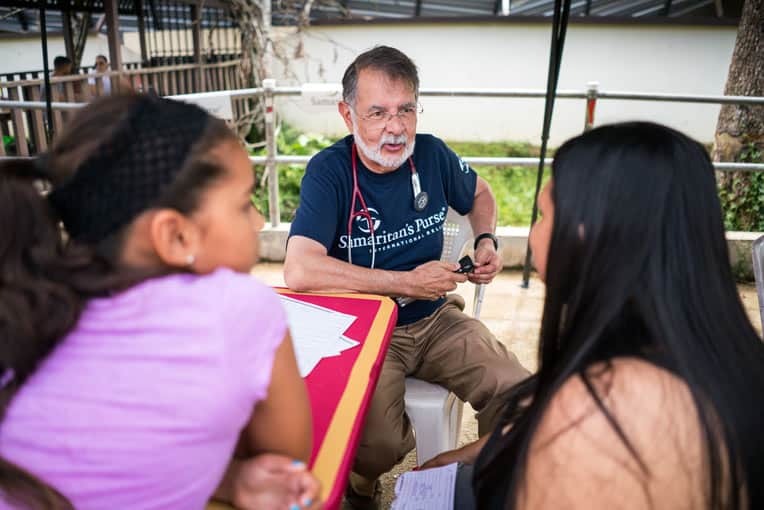 >Dr. Carlos de la Garza listened with compassion as he saw patients with a variety of ailments.