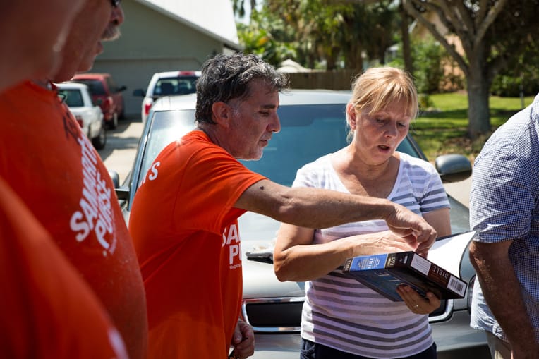 Volunteers present Marta with a Bible signed by everyone who worked on her home.