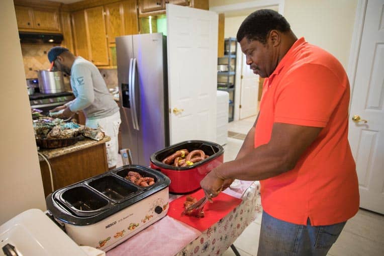 George Dorsey and his son, George III, prepare sausages, gumbo, and brisket to celebrate with Samaritan’s Purse staff and volunteers.