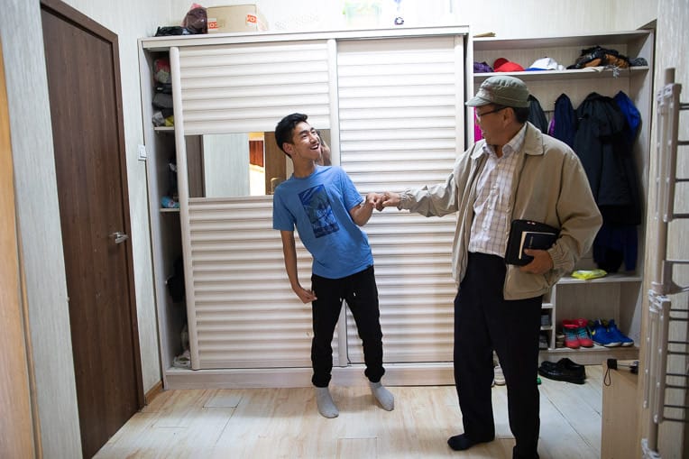 Chuka (right) greets Sampil with a fist bump when he stops by his home.