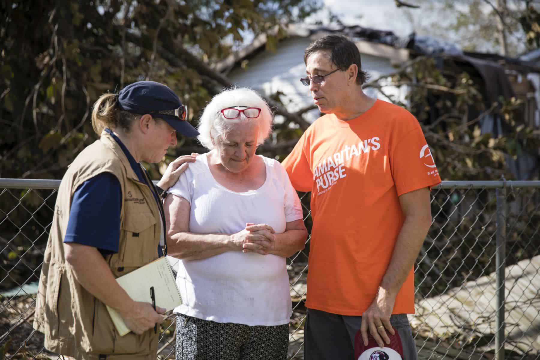 Canadian Disaster Relief Manager Tammy Suitor prays with Pastor Mike and a homeowner.