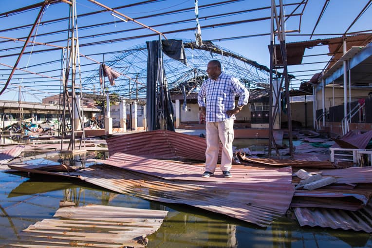 Pastor Daniel surveys the property of his church where hurricane winds and floodwaters wrecked the worship space.