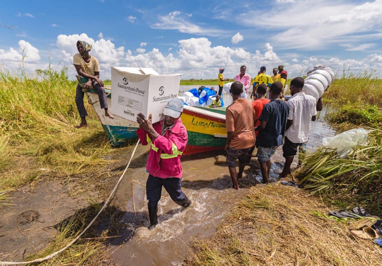 Emergency relief supplies are delivered by boat to remote villages.