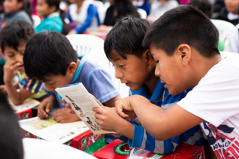 Children eagerly read The Greatest Gift Gospel booklet they received with their shoebox gifts.