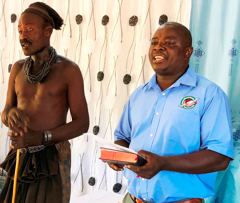 The village chief (left) who donated the land for the church spoke at the dedication ceremony while Pastor Rizera (right) translated his words for the international guests.