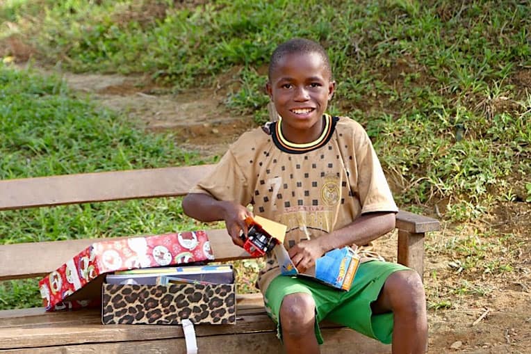 A boy from Vanyanpa enjoys unpacking his shoebox gift.