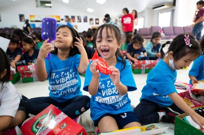 Children celebrate the special shoebox gifts they received at the Operation Christmas Child outreach event.