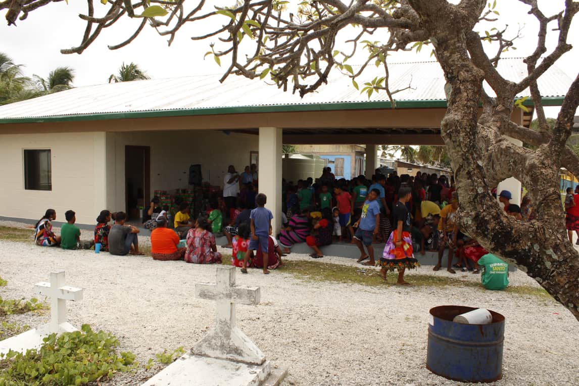 Children gathered under a covered patio while their parents gathered around the edges.