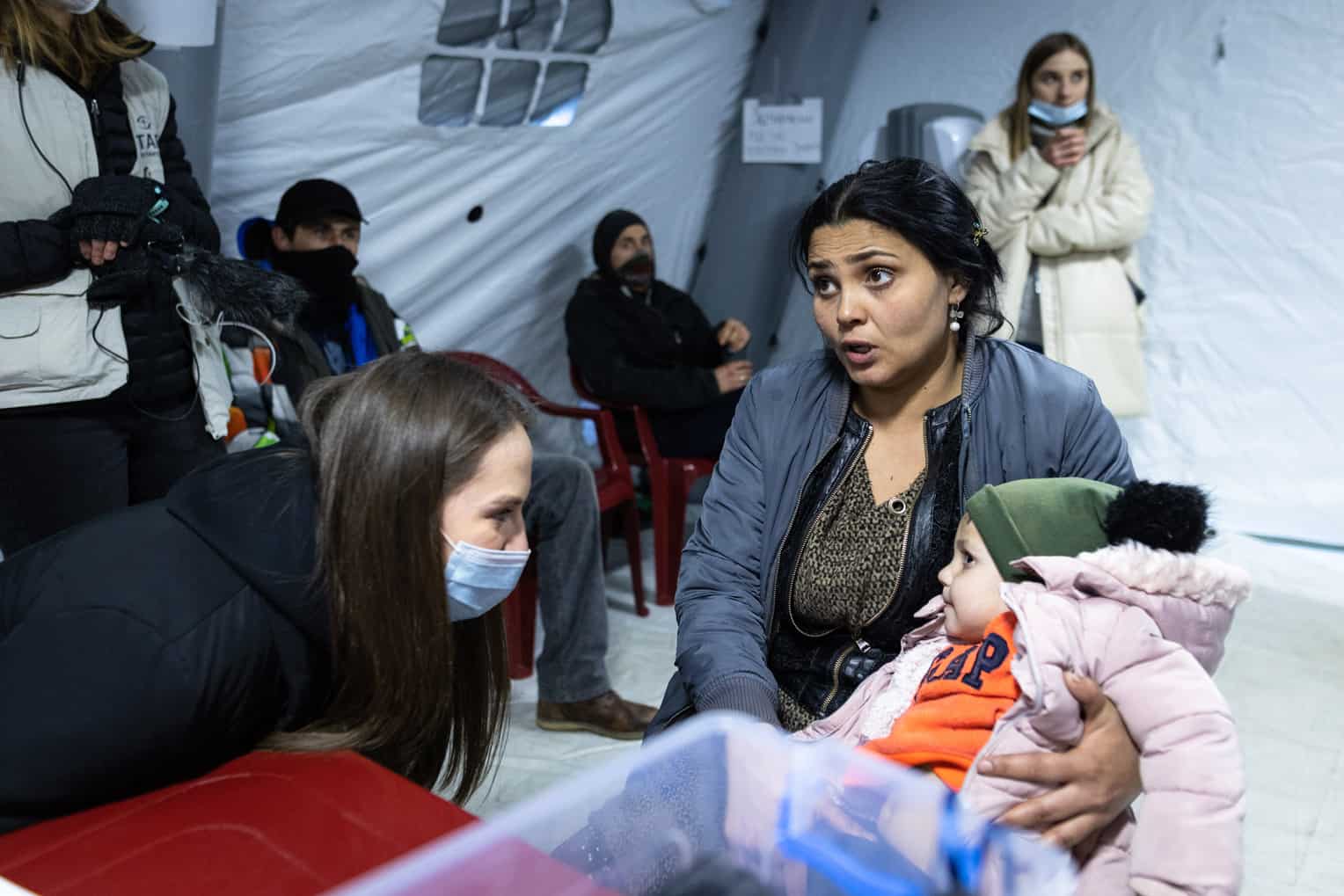 Olya rushed into the white tent carrying her two-year-old son, Kimal