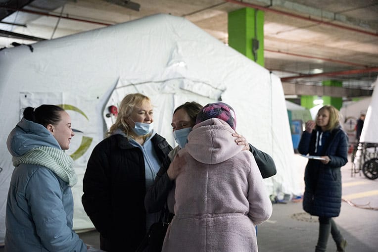 Marina shares a hug with Jonie, one of our nurses. Her daughter, far left, came with her to the hospital.