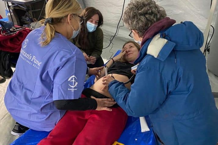 A pregnant woman hears her baby's heartbeat, crying tears of relief at our field hospital in Ukraine.