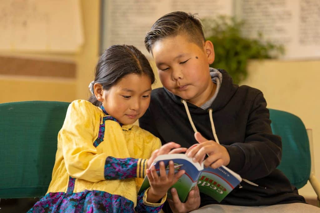 Boys and girls enjoy the New Testaments they receive at their graduation from The Greatest Journey.