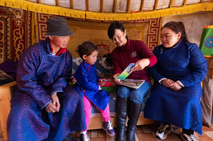 An Operation Christmas Child volunteer presents the Gospel to Amina and her family before giving her a gift-filled shoebox.