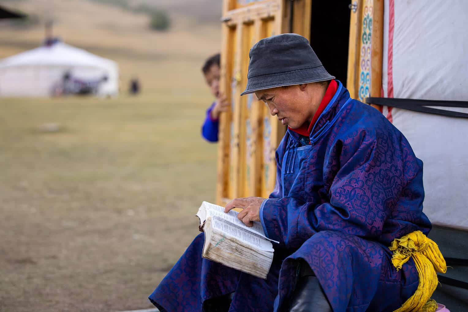 Amina peeks to see what her father is reading. Baljinnyam hopes that one day she’ll read the Bible, too.