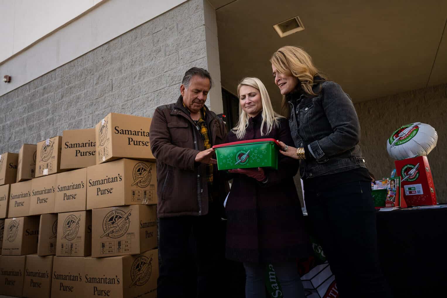 K-LOVE DJs pray with Elizabeth over the shoebox she packed in Denver.