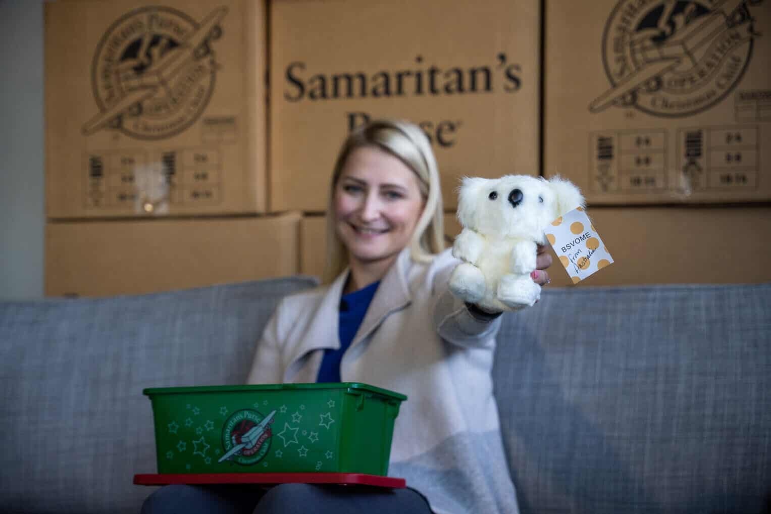 Elizabeth displays one of the "wow" items going in her shoebox gift. In this case, it's a stuffed koala toy from Australia.