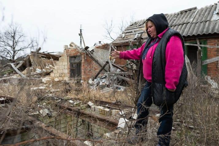 Olga surveys the ruins of her property in far eastern Ukraine. Before the war, she prized her garden and summer kitchen.