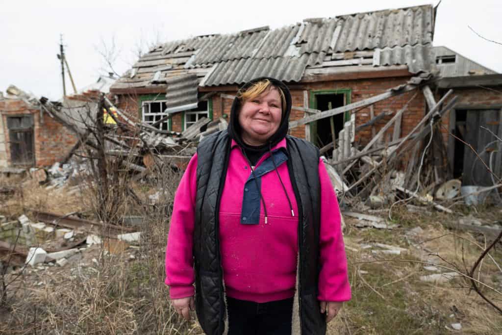 Olga stands in the midst of war's destruction. 