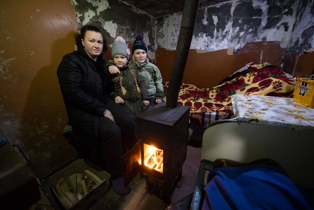 Olena and her children huddle in their cellar next to a stove provided by  Samaritan's Purse.