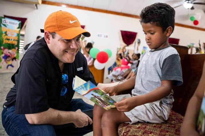 Andy Castillo reads with a young boy at a recent Operation Christmas Child outreach event in Honduras.