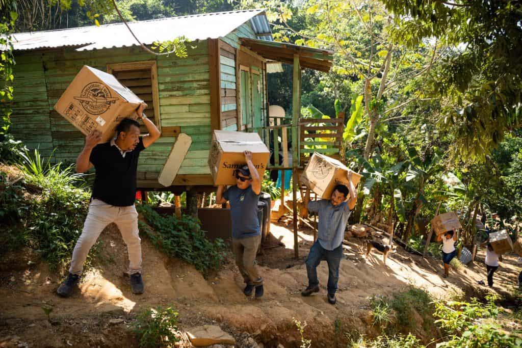 Team members haul shoebox gifts uphill to an outreach event at a church in Honduras.