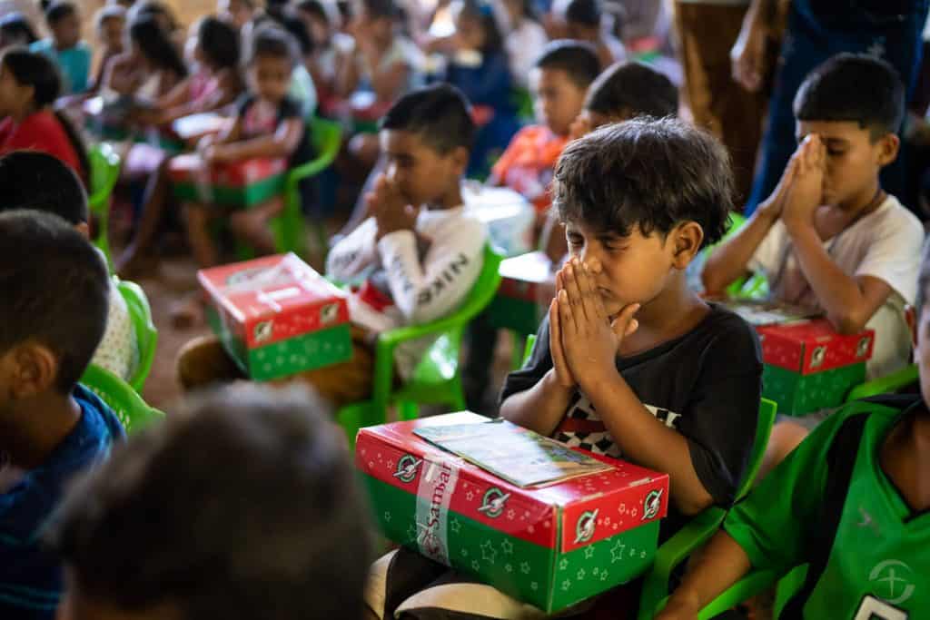 Children in Honduras pray before opening their Operation Christmas Child shoebox gifts.