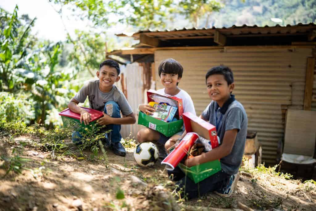 A group of boys in Honduras are all smiles as they enjoy the contents of their shoebox gifts.