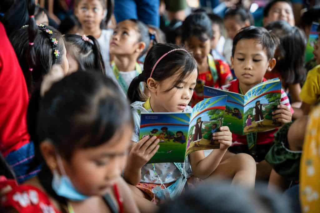 Children enjoy reading the Gospel stories in The Greatest Gift booklet.