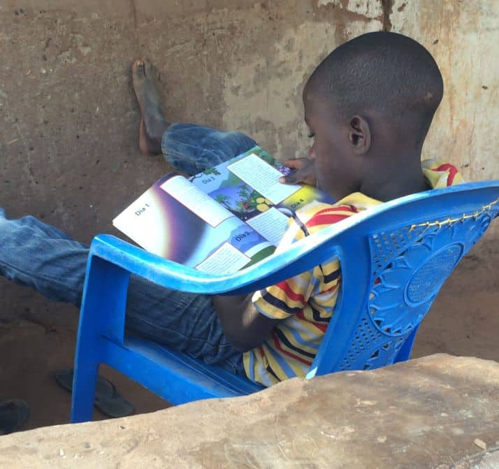 A child in Guinea Bissau takes some time alone to read about Jesus in a booklet Samaritan's Purse supplies to all participants in The Greatest Journey.