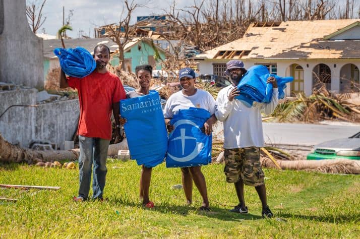 Gerald (far left) and Rosie (second from right) stand with their neighbors after receiving shelter plastic from Samaritan's Purse.