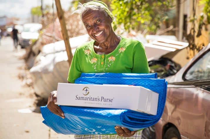 A beneficiary in Puerto Rico receives a hygiene kit and shelter plastic from Samaritan's Purse.