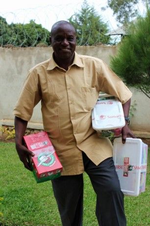 The pastor poses smiling with shoeboxes