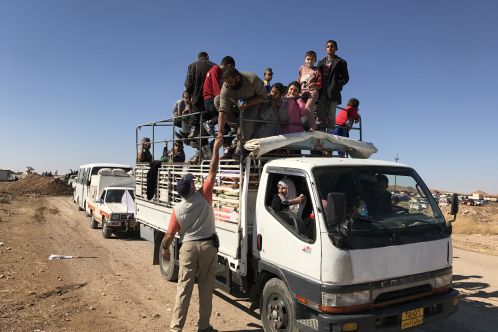 Refugees in truck with Samaritan's Purse staff reaching up
