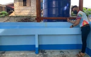 Principal Ramos tries out the new handwashing stations built at his school. 