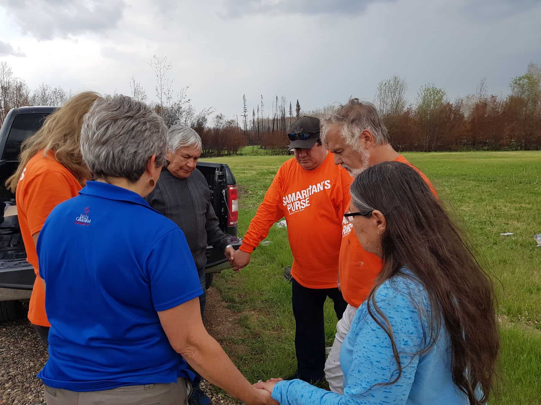 Samaritan's Purse volunteers and Billy Graham Rapid Response Team chaplains pray with homeowners.