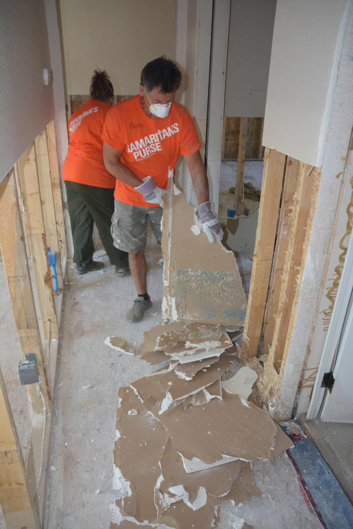 A Samaritan's Purse volunteer helps strip away moldy drywall in Grand Forks, B.C.