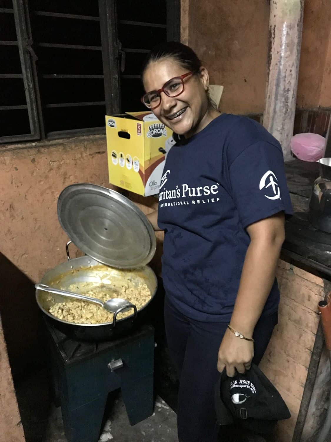 One of our employees, preparing a hot meal for Venezuelan migrants at our roadside facility called the "Shelter of Hope".